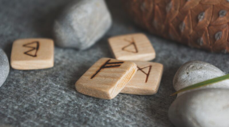 Wooden runes and stones scattered on wool plaid
