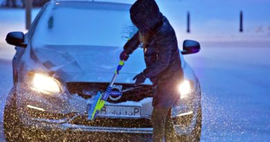 man in brown jacket riding blue snow sled during daytime