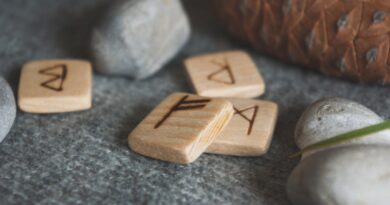 Wooden runes and stones scattered on wool plaid