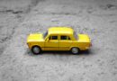 yellow sedan die-cast on gravel