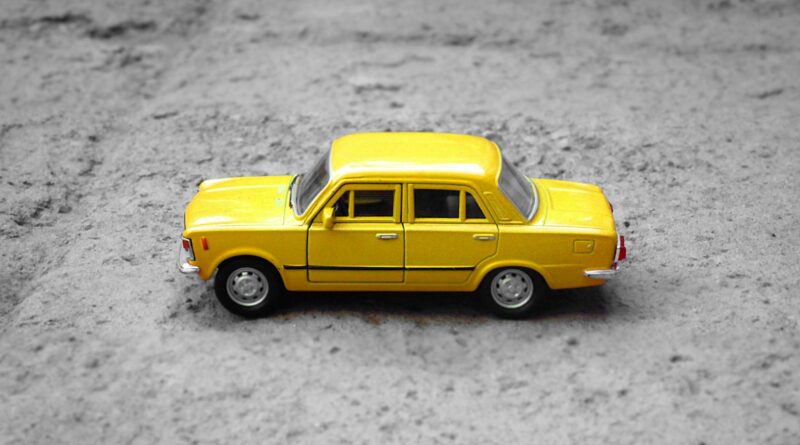 yellow sedan die-cast on gravel