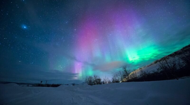 northern lights over snow-capped mountian