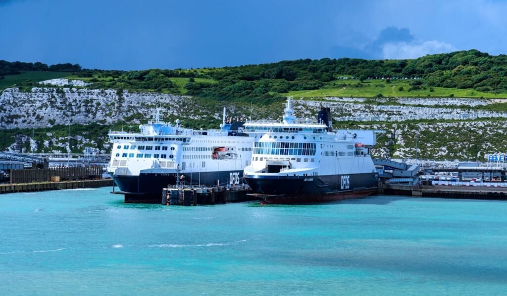 Ferry boats at Dover harbor with iconic white cliffs in the background. Captured on a sunny day in England.