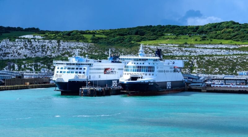 Ferry boats at Dover harbor with iconic white cliffs in the background. Captured on a sunny day in England.